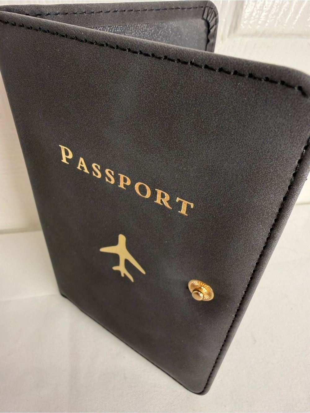 PASSPORT COVER HOLDER WITH GOLD LETTERING AND PLANE DETAIL IN BLACK & GOLD